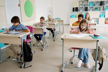 Pupils studying writing notes classroom primary