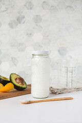 Coconut oil jar on kitchen counter with fresh ingredients 