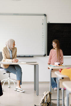 Muslim teacher observes student's classroom presentation