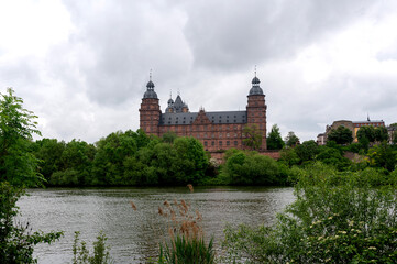 Fototapeta na wymiar Castle in Aschaffenburg with a river and a cloudy sky