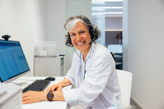 Cheerful middle aged woman sitting at table
