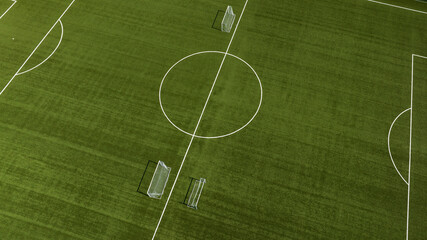 Aerial closeup of the midfield circle in an empty synthetic grass football field. Here the kick off...