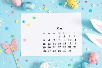 Easter concept. Flat lay, top view of paper desk calendar for May 2024 , easter bunny ears,...