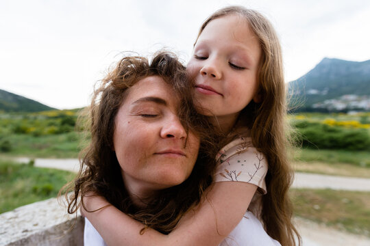 Hugging woman and daughter on terrace