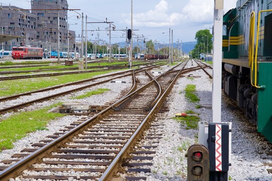 Railway station of Ljubljana with railway tracks and switches and parked green shunting diesel locomotive on a cloudy summer day. Photo taken August 9th, 2023, Ljubljana, Slovenia.