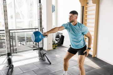 Muscular male athlete exercise with kettlebell