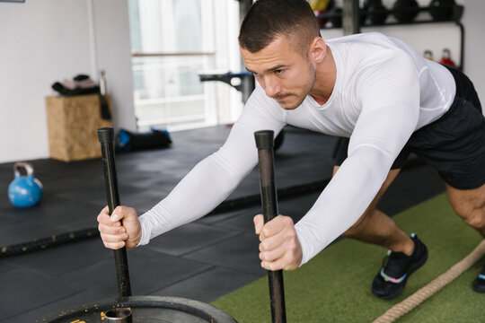 Athlete man exercising in the gym pushing weights