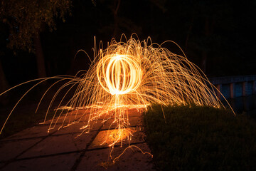 Fireball - spinning steel wool in a park. Sparks flying out in all directions due to centrifugal...