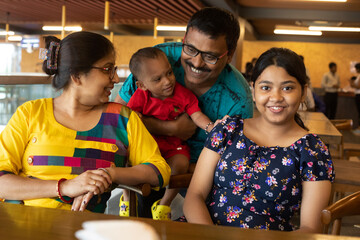 Indian family photograph sit inside a restaurant in holiday time