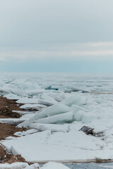 Blocks of ice on the lake in spring. Vertical photo.
