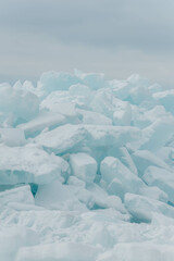 Fototapeta na wymiar Blocks of ice on the lake in spring. Vertical photo.