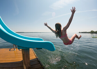 Young girl Swimming at finger lakes lake on slide in summer vacation 