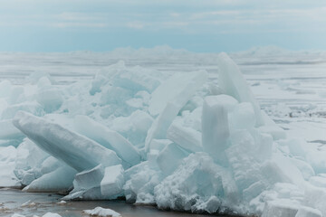 Fototapeta na wymiar Blocks of ice on the lake in spring. Horizontal photo.
