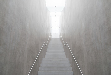 Empty narrow staircase leading up to the light. Concrete walls and illuminated ceiling made of satin glass. Handrails on both sides. Photo in grey tones, almost monochrome.