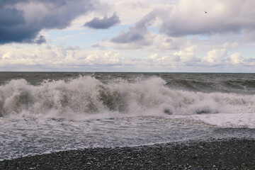 Black Sea at sunset. Waves on the sea, sea foam and sand.