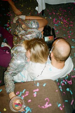 Young man and woman lie on the floor during a party
