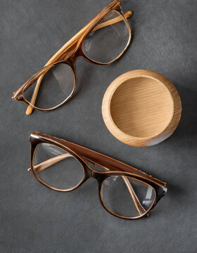 Vista superior de gafas con marco de madera sobre un escritorio de fondo oscuro para maqueta, colección de ángulos diversos, espacio de copia
