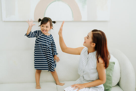 happy smiling mother and daughter looking at each other