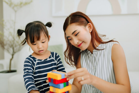 Happy family playing jenga together at home,