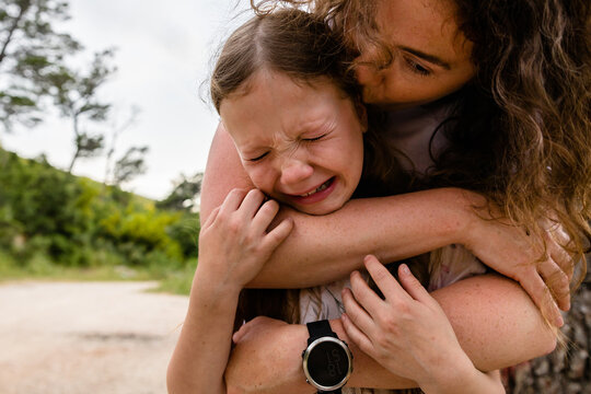 Crying child in mother's arms