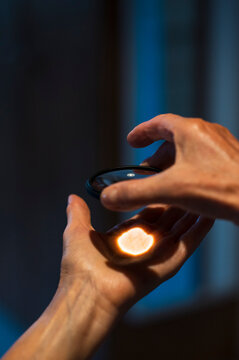 Hands holding glass lens