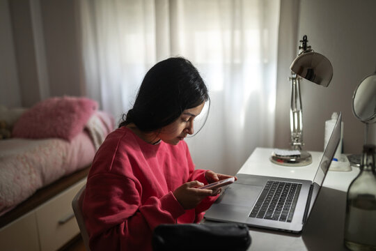 teen girl with mobile phone in her bedroom
