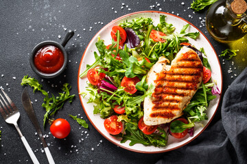 Healthy food. Chicken steak BBQ grill meat with fresh salad on black background. Top view.