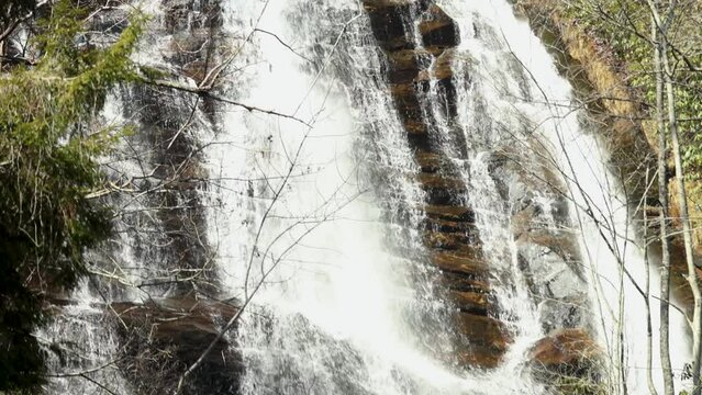 footage of rushing water of the waterfall at Anna Ruby Falls with lush green trees and plants in Helen Georgia USA