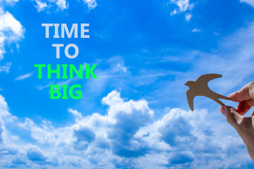 Time to think big symbol. Concept words Time to think big. Beautiful blue sky cloud background. Voter hand with wooden bird. Business and time to think big concept. Copy space.