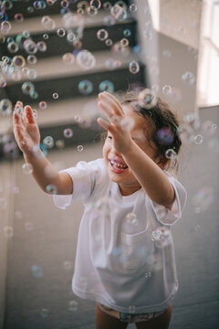 Cute little girl playing with bubbles