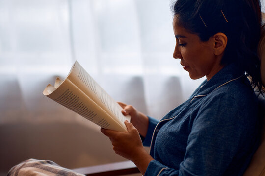 Mid Adult Woman Enjoying In Reading  Book At Home.