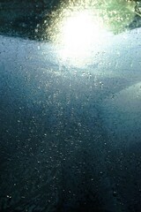 Abstraktes Motiv mit Eismuster auf Glasscheibe mit weißer Sonnenreflexion bei Sonne, Frost und Kälte am Morgen im Winter - obrazy, fototapety, plakaty