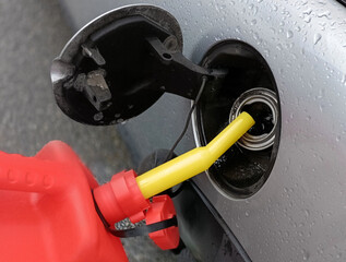 pouring fuel into the gas tank from a canister
