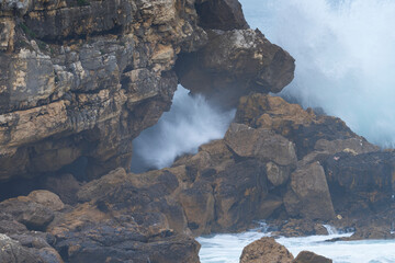 Natural arch on the coast of Santander and storm surge with big waves. Santander Municipality....