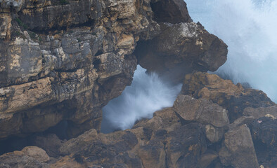 Natural arch on the coast of Santander and storm surge with big waves. Santander Municipality. Cantabrian Sea. Cantabria. Spain. Europe