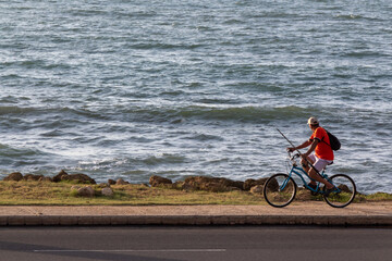 Obraz premium man rides his bicycle along the Caribbean coastline in Cartagena.