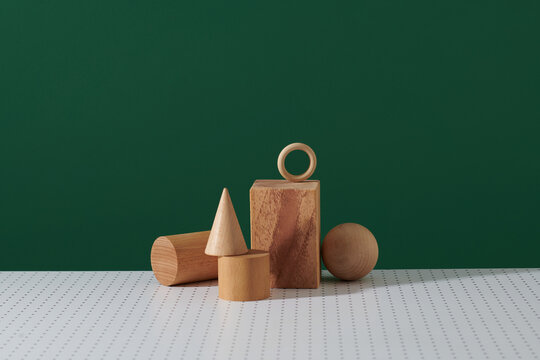 Many geometrical wooden figures on green background.