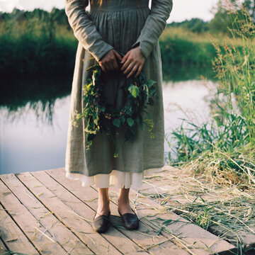 Anonymous woman holds a wreath in her hands.