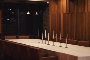 Table with candles in restaurant. Elegant table setting for dinner. Calm romantic atmosphere.