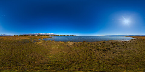 seamless 360 by 180 degree spherical panorama of mountain lake Issyk-Kul shore at sunny autumnal day
