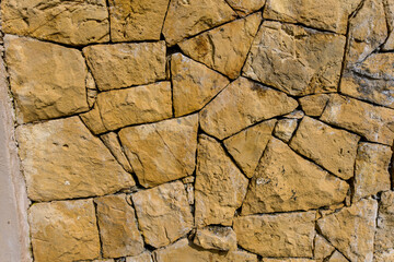 Brown natural old stone wall. Building stone walls, garden stone wall historic wall. Light brown stone construction