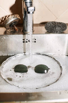 sunglasses are washed in the foam in the sink