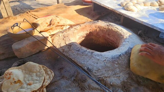 A man making roti on tandoor, Making of bread in village in Punjab. It is made from whole wheat and baked in tandoor oven. Abstract shot of making roti.
