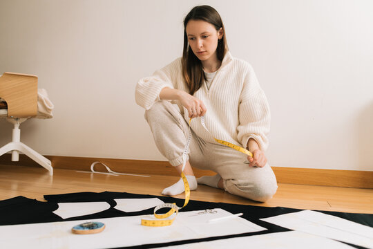 Woman thinking while looking at pattern and fabric