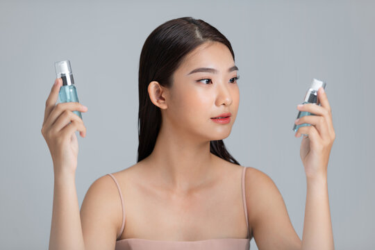 Woman with two serum bottles and choosing beauty skincare product