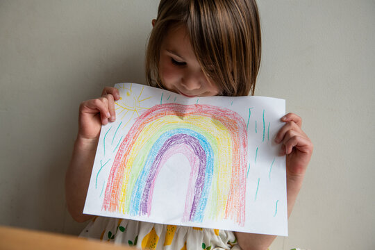 Child Shows a Rainbow Drawing She Colored with Crayons