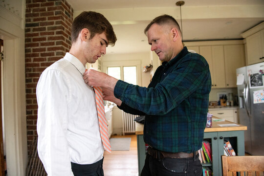 Father Helps Teen Son with Tie Dressing for Prom