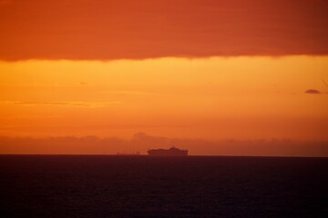 Schiff am Horizont bei Sonnenaufgang