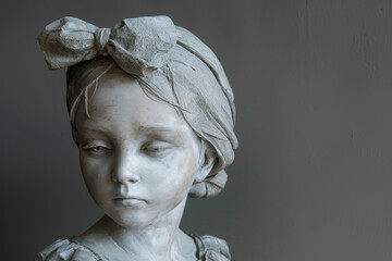 A sculpture of a young girl with a material or a shape or a style