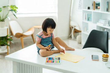 Little baby girl drawing with crayon color on paper